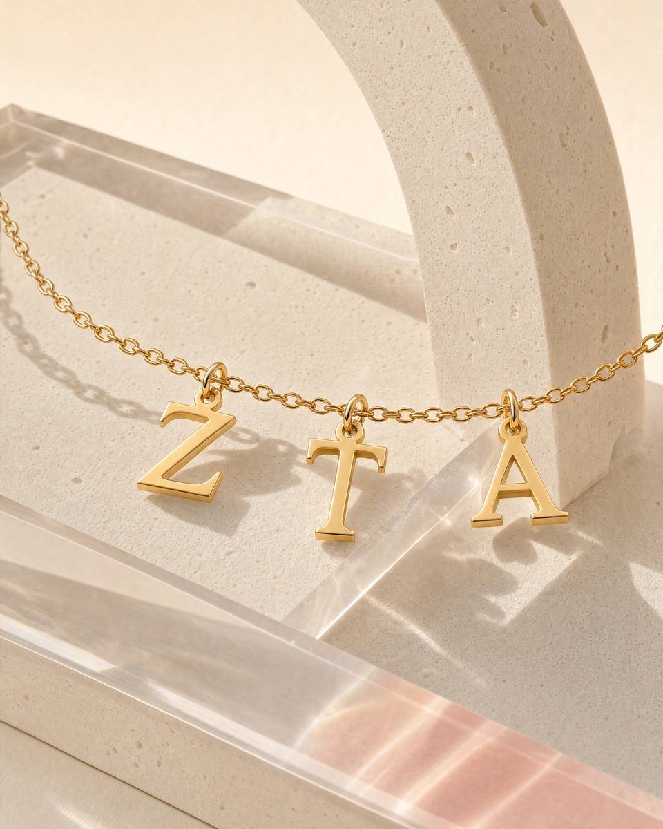Zeta Tau Alpha gold letter pendants on sculpted cream paper