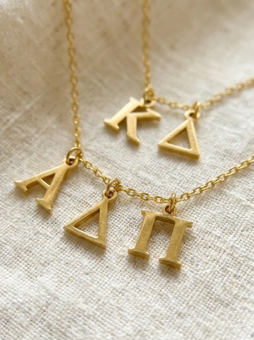 Custom gold Greek-letter pendant charms, close up